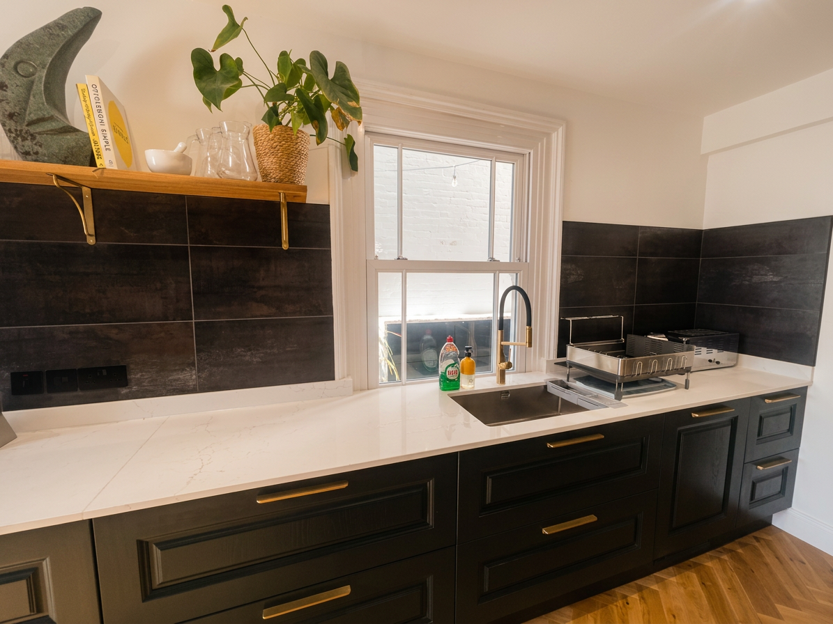 Hastings House kitchen sink and worktop with dark tiled splashback